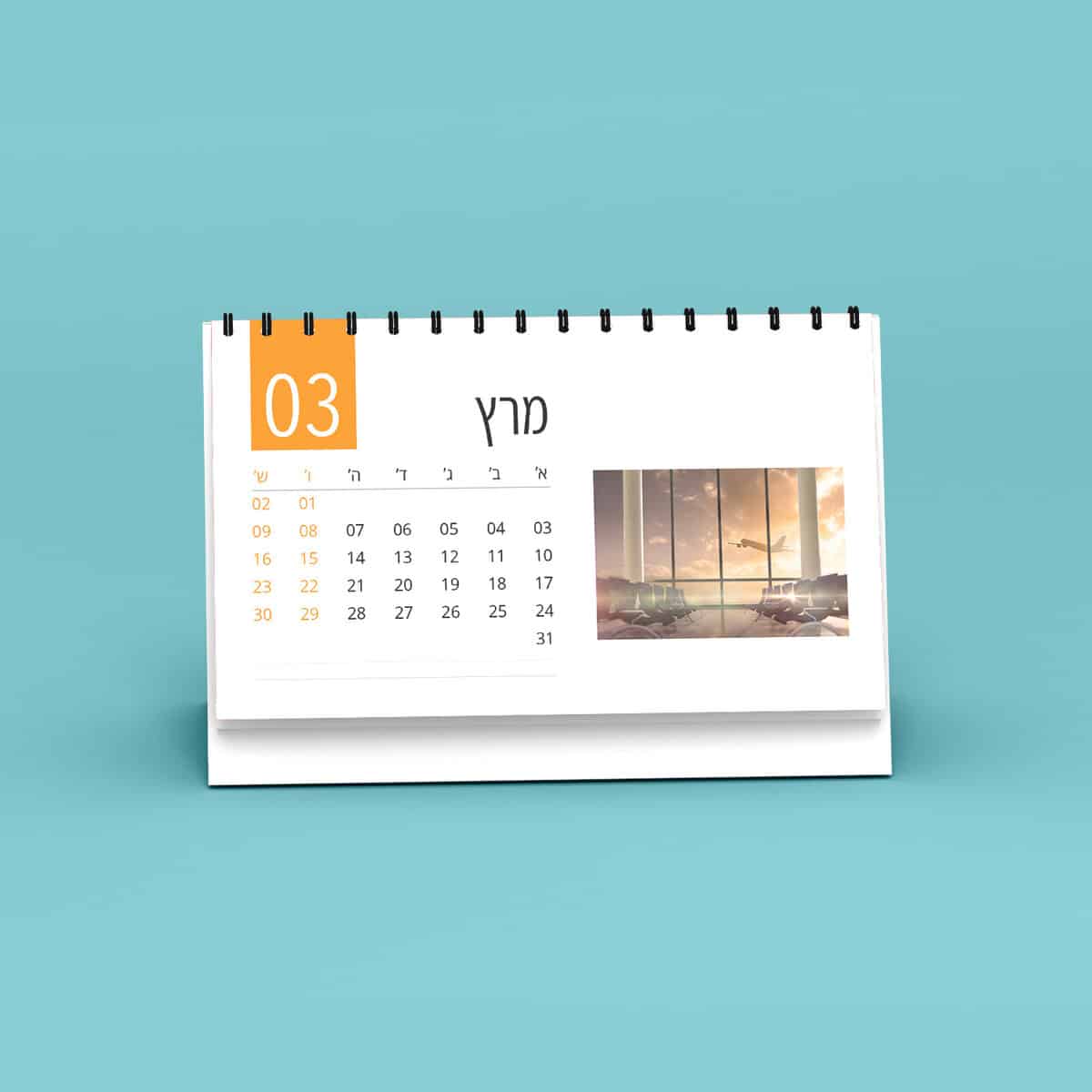 לוח שנה שולחני ממותג מונח על רקע כחול כאשר הוא מציג את חודש מרץ.